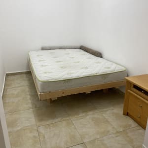 חדר עם רצפה נקייה ומיטה מסודרת