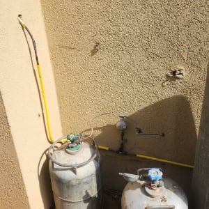 שני בלוני גז מחוברים לקיר חיצוני