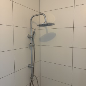 מקלחת עם ראש מקלחת וכותלי קרמיקה