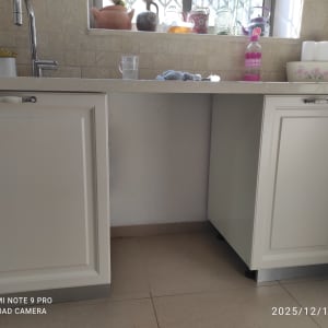 ארונות מטבח לבנים עם משטח עבודה וכיור