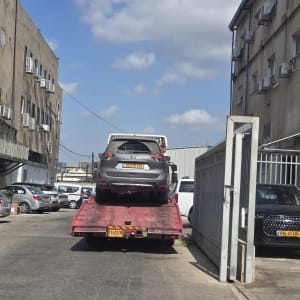רכב על גרר בחניון עם שמיים כחולים