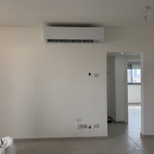 מזגן מותקן על קיר בחדר ריק עם רצפת אריחים