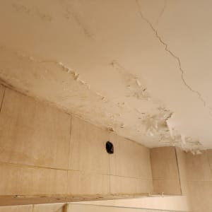 תקרה מתקלפת עם סדקים וכתמי רטיבות