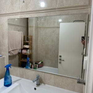 מראה גדולה מעל כיור בחדר אמבטיה