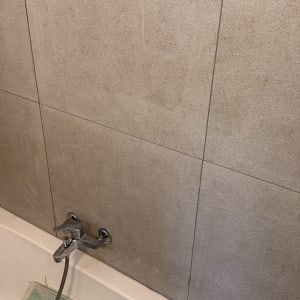 ברז אמבטיה על רקע קיר אריחים