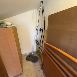 חוטים חשמליים חשופים בקיר עם לכלוך על הרצפה