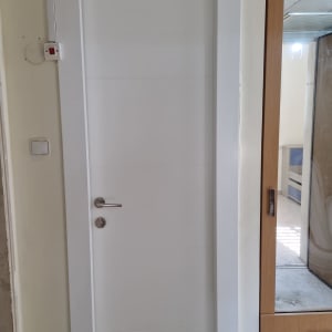 התקנת דלת פנים לבנה מעוצבת עם הלבשות וידית נירוסטה
