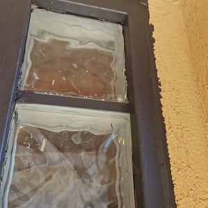 חלון עם מסגרת כהה על קיר צהוב
