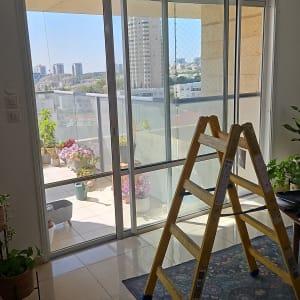 סולם ליד חלון עם תריסים במרפסת