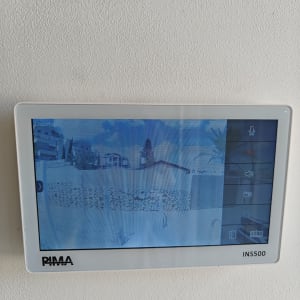 מסך אינטרקום מותקן על קיר לבן