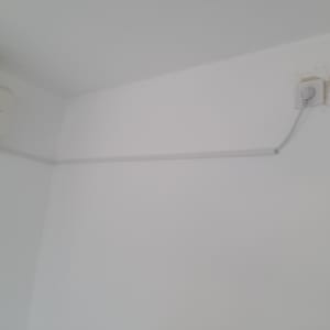 שקע חשמל עם כבל מחובר לקיר לבן