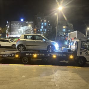 גרר עם רכב על משאית גרירה בלילה