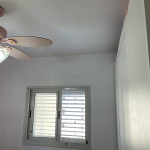 קיר גבס לבן עם חלון ותריסים