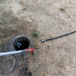 פתח ביוב עם כלי ניקוי על אדמה יבשה