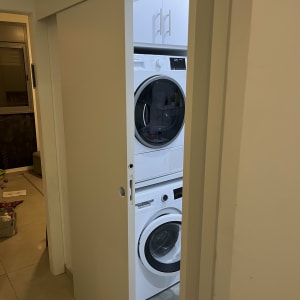 דלת הזזה לבנה עם מכונת כביסה מאחוריה