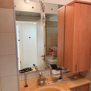 מראה עם סרטי הדבקה בתחום הזכוכית בחדר אמבטיה