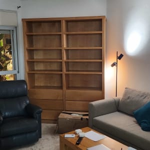 חדר עם כוננית עץ, ספה ושולחן עם חפצים