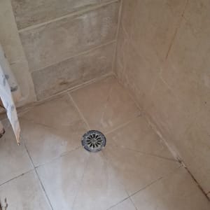 רצפת מקלחת עם אריחים וניקוז במרכז