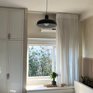 מנורה תלויה בחדר שינה עם חלון ווילון לבן