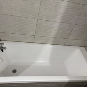 אמבטיה לבנה עם ברז ומוצרים בצד