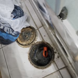 פתח ביוב פתוח עם מכסה וידית כתומה