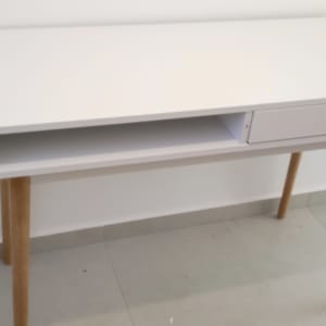 שולחן לבן עם מגירה ורגלי עץ