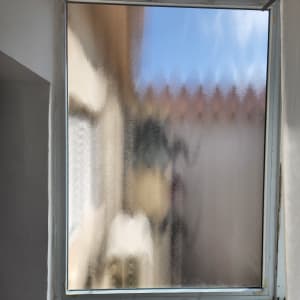 חלון זכוכית עם נוף מטושטש ברקע