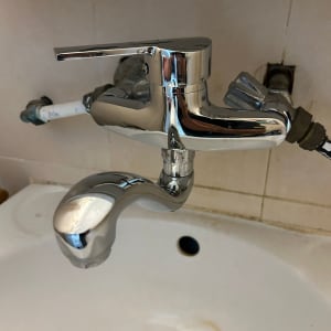 ברז כרום מותקן על כיור עם צינורות חשופים