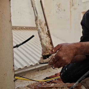 אדם עובד על דוד שמש עם צינורות וכלים