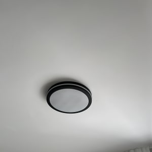 מנורת תקרה עגולה מותקנת על תקרה לבנה