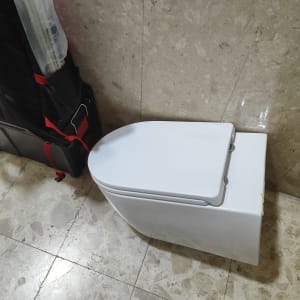 אסלה לבנה ליד תיק כלים של אינסטלטור