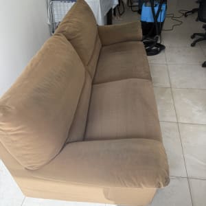 ספה חומה עם ציוד ניקוי ברקע