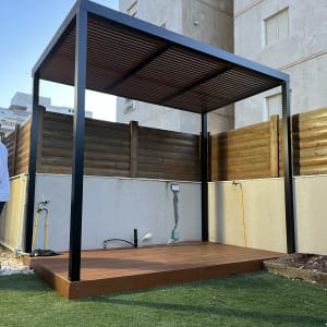 פרגולה מעץ עם רצפת דק בגינה