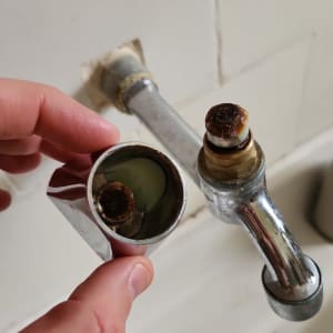 ברז מפורק עם חלודה, יד מחזיקה חלק