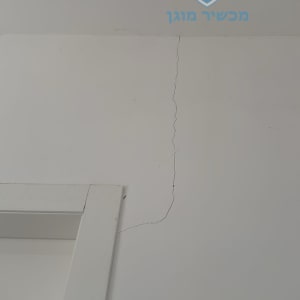 קיר עם סדק ליד משקוף דלת