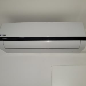 מזגן קיר לבן מותקן על קיר פנימי