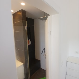 מקלחת עם אריחים כהים וברז כסוף