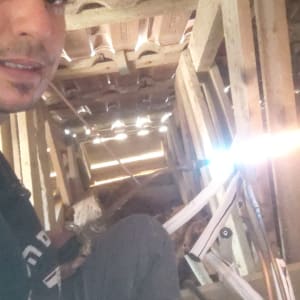 אדם עובד על התקנת מערכת מיזוג אוויר בעליית גג