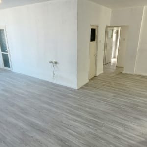 חדר ריק עם רצפת פרקט וחלון גדול