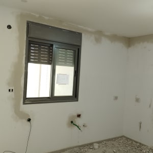 קיר עם חוטי חשמל חשופים ושקעי חשמל