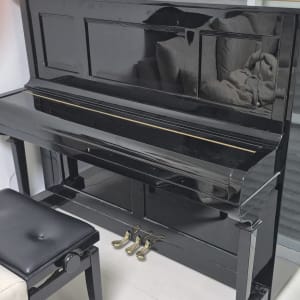 פסנתר שחור עם כיסא ליד חלון