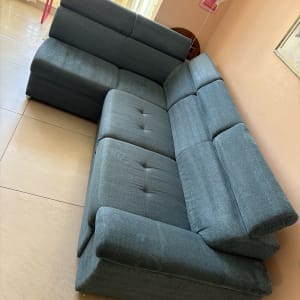 ספה כחולה בחדר מואר עם קישוטים על הקיר