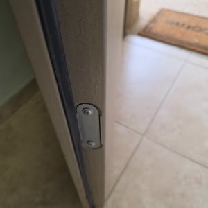תקריב של דפנות דלת ממ"ד עם אטם גומי ולוחית מתכת מוברגת