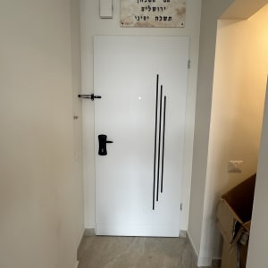 דלת עם עיצוב קווים שחורים על רקע קיר לבן