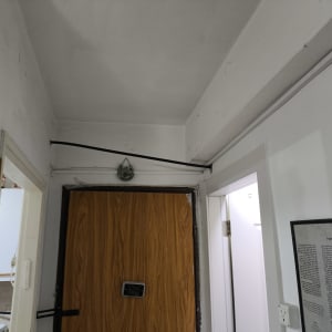 חוטי חשמל מותקנים על קיר ליד דלת