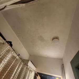 תקרה עם סימני רטיבות ותאורה בחדר אמבטיה