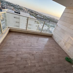 מרפסת נקייה עם רצפת עץ וצינור ירוק