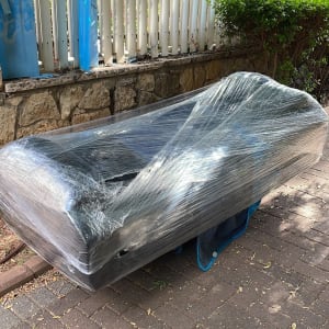 ספה עטופה בניילון נצמד על מדרכה