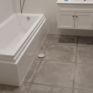 חדר אמבטיה עם אמבטיה, ארון כיור ורצפה חדשה