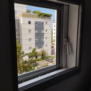 חלון אלומיניום פתוח עם נוף חיצוני